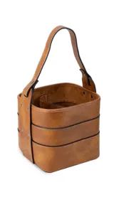 Porta termo y mate tipo balde, color negro, confeccionado en símil cuero con costuras blancas visibles. Posee una asa reforzada y una división interna.