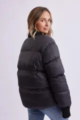 Campera puffer negra con cuello en V, cierre frontal con botones a presión y puños tejidos.