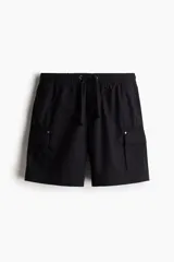 Short cargo negro de popelina de algodón, con cintura elástica ajustable con cordón, bolsillos laterales, bolsillos cargo con solapa y botón a presión en piernas y traseros, y aberturas laterales en el bajo.