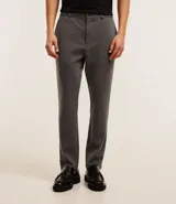 Pantalón de vestir gris con textura, corte slim, con trabillas en la cintura y cierre por botón y cremallera.