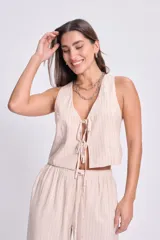 Chaleco corto color crudo con rayas verticales finas, escote en V y cierre frontal con lazos.