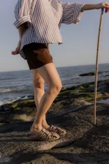 Sandalias tipo mule de cuero color marrón chocolate, con diseño de tiras anchas cruzadas y suela plana.