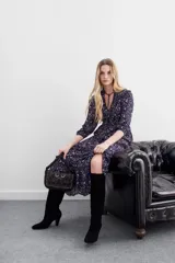 Vestido midi de viscosa con lurex, estampado floral en tonos azul y blanco. Tiene mangas largas abullonadas, escote redondo con abertura y lazo, y volados en la falda, mangas y cuello.