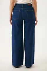 Pantalón de jean azul con corte acampanado y diseño de bloques de color en diferentes tonos de azul.