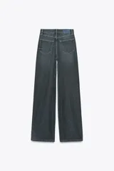Pantalón de jean de tiro alto color gris oscuro, corte recto, con bolsillos delanteros y traseros. Cierre frontal con cremallera y botón.