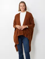 Ruana de tejido suave color morado oscuro, con cuello redondo y corte amplio tipo capa.