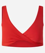 Top deportivo de microfibra color rojo, sin copa, con breteles rectos, escote en V y detalle de torcido en el busto.