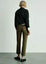 Pantalón de jean verde militar, de tiro medio, corte acampanado y largo cropped. Presenta bolsillos de parche delanteros y traseros, trabillas y terminación desflecada.