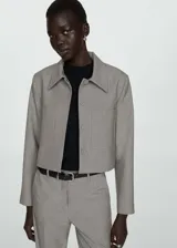 Chaqueta corta gris con cuello camisero, cierre frontal con botones ocultos, dos bolsillos de parche delanteros y forro interior.
