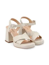 Sandalias de cuero color canela con plataforma y tacón ancho. Tiras cruzadas en el empeine y pulsera ajustable con hebilla en el tobillo.
