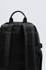 Mochila negra con acabado engomado, múltiples bolsillos frontales con cierre y bolsillos laterales. Cuenta con compartimento interior acolchado para dispositivos electrónicos de hasta 13 pulgadas, parte posterior acolchada y asas de hombro ajustables.