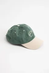 Gorra de béisbol de color verde oscuro con efecto lavado, visera de color beige claro y bordado frontal de una pelota de fútbol americano en hilo color beige.
