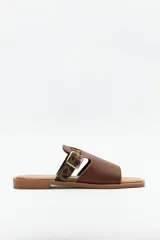 Sandalias bajas marrones con suela acolchonada y taco de 2cm. Capellada de símil cuero texturizado con tira de animal print y hebilla ajustable.