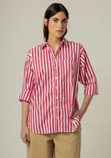 Camisa de manga larga con rayas verticales rojas y blancas, cuello clásico y bolsillo en el pecho.