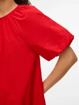 Vestido corto de algodón color rojo, con mangas globo y cuello redondo. Corte suelto y textura liviana.