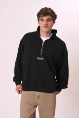 Sudadera negra con cierre de cremallera metálica en el cuello y estampado con texto en el pecho.