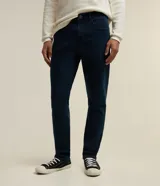 Pantalón de jean azul oscuro, corte slim, con trabillas en la cintura y bolsillos.