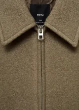 Chaqueta marrón de tejido mezcla de lana con forro interior, cuello camisero, cierre delantero con cremallera, dos bolsillos laterales y diseño oversize.
