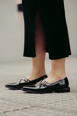 Chatitas de cuero con estampado animal print, con dos tiras cruzadas sobre el empeine y hebillas metálicas.