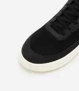 Championes Viko de hombre, color negro con suela blanca, confeccionados en poliéster con recortes y suela de EVA. Diseño casual y confortable.