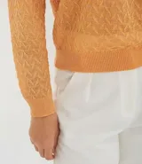 Blusa color naranja de tricot con cuello redondo y mangas largas.