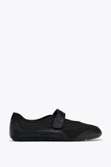 Zapato tipo bailarina color negro, con capellada de rejilla y cierre con tira de velcro.