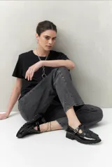 Pantalón jean gris oscuro de corte recto, tiro alto y calce relajado. Presenta apliques metálicos en los laterales.