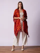 Kimono tejido con estampado geométrico en blanco y negro, ruedo con borlas y composición 100% poliéster.