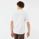 Camisa blanca de lino con cuello mao, manga corta con dobladillo y cierre frontal con botones.