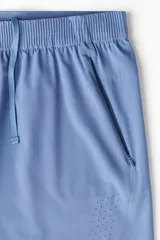 Short deportivo celeste a media pierna, confeccionado en tejido funcional DryMove™ que absorbe el sudor. Cuenta con cintura elástica con cordón ajustable, bolsillos laterales con cierre, orificios de ventilación cortados a láser y abertura lateral en el bajo.