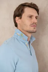 Remera tipo polo color beige, de manga corta y corte clásico. Tiene cuello con botones y está confeccionada en algodón.