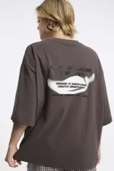 Remera blanca de algodón con cuello redondo y manga corta. Estampado pequeño de un ají rojo en el centro del pecho.