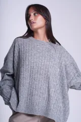 Sweater oversize tejido en punto trenzado color gris, con cuello redondo y mangas largas.