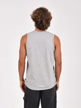 Musculosa blanca de cuello redondo y sisa amplia, con un estampado frontal de estilo fotográfico en blanco y negro que muestra un paisaje desértico y una construcción, acompañado por la palabra "wilderness" en color verde.