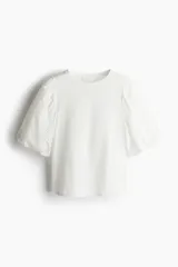 Top blanco de algodón con cuello redondo y mangas globo cortas de algodón bordado con forro de punto y ribete elástico.