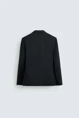 Blazer regular fit color negro confeccionada en tejido de lana. Cuello con solapas de muesca y manga larga acabada en puño con detalle de botones. Bolsillos de vivo en pecho y de solapa en cadera. Detalle de bolsillo interior. Bajo con aberturas en espalda. Cierre frontal de botonadura.