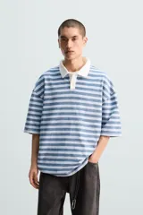 Polo de hombre a rayas horizontales azules y blancas, con cuello clásico blanco y corte relaxed fit.