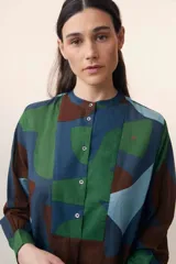 Vestido largo de verano de algodón con estampado abstracto en tonos azul, verde y marrón. Presenta cuello mao, pechera con botones y corte evasé.