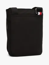 Bandolera Tommy Hilfiger negra de poliéster con acabado texturizado. Tiene correa ajustable, cierre de cremallera, bolsillo interior y exterior con cremallera, logo de Tommy Hilfiger grabado en bajo relieve en el interior y logo metálico en la parte delantera.