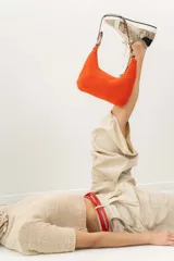 Cartera de hombro tejida a crochet color verde, con asa de cuero marrón y cierre.