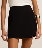 Short pollera negro confeccionado en crepé con traspase envolvente.