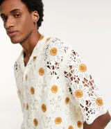 Camisa masculina de corte boxy, color crudo con diseño calado de ganchillo y girasoles color mostaza.