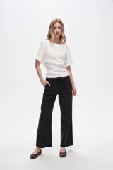 Pantalón jean negro de corte recto, tiro medio y ruedo desflecado.