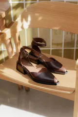 Sandalias de cuero color marrón chocolate, con punta fina y tira al tobillo con hebilla.