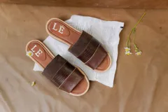 Sandalias de cuero negras con diseño de tiras cruzadas y detalle de elástico en el talón.