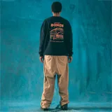 Buzo negro de corte clásico con cuello redondo y puños y cintura acanalados. Estampado pequeño de un autobús escolar en el centro del pecho.