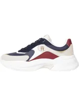 Zapatillas Tommy Hilfiger estilo running con suela gruesa, diseño color block en azul marino, beige y blanco, detalles distintivos metálicos y logo dorado en la lengüeta.