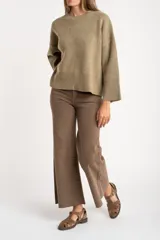 Sweater de punto color tostado con calce oversize, cuello redondo y mangas largas anchas. Presenta terminaciones acanaladas en cuello, puños y ruedo.