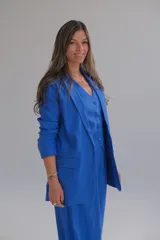 Blazer azul de lino, con solapa de muesca, cierre frontal con botones y bolsillos laterales.