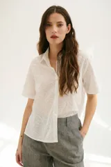 Camisa blanca de mangas cortas con estampado de hojas.